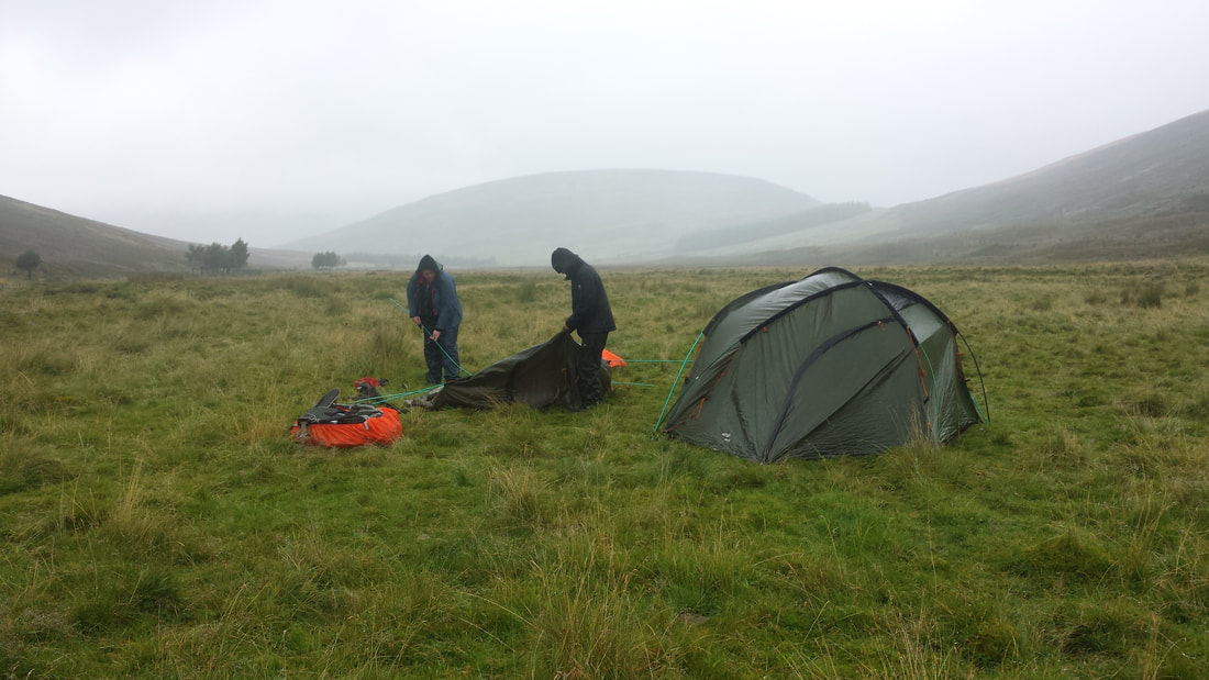 2 DofE students putting tents up in the rain